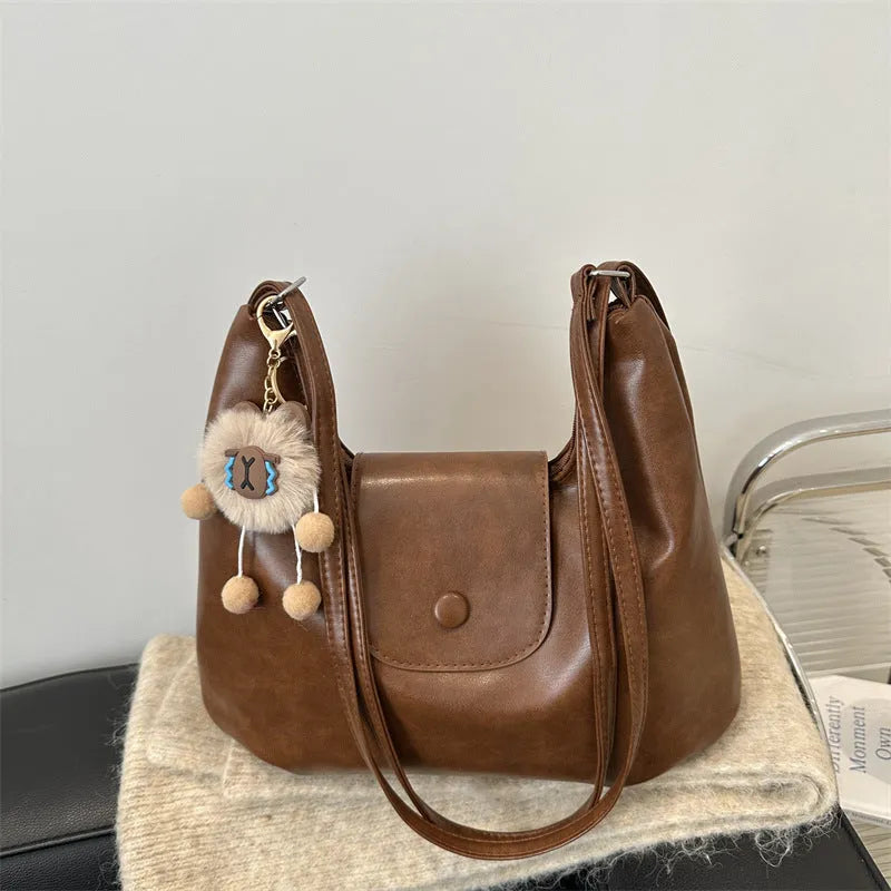 Textured PU leather commuter shoulder backpack in horizontal square shape with single strap and mobile phone compartment