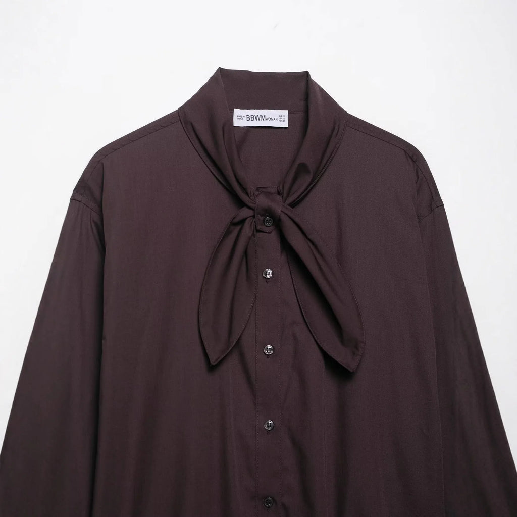 Brown women's poplin shirt with long sleeves, a bow tie, and a loose cardigan fit.