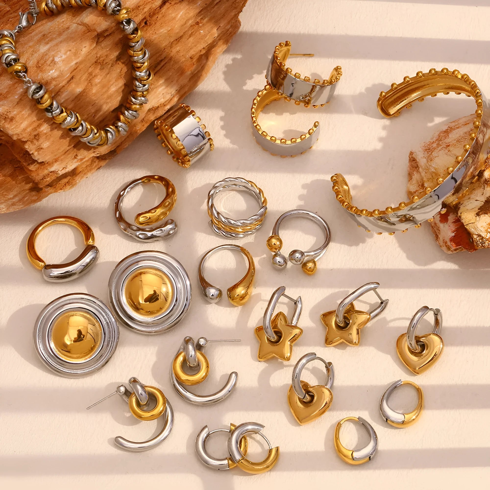 Gold electroplated geometric jewellery set with earrings, bracelet and necklace on white background