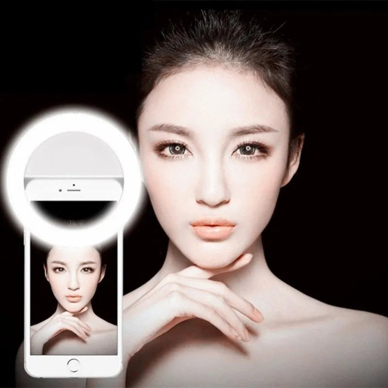 Green selfie ring light clip with LED bulbs attached to a mobile phone for photography.