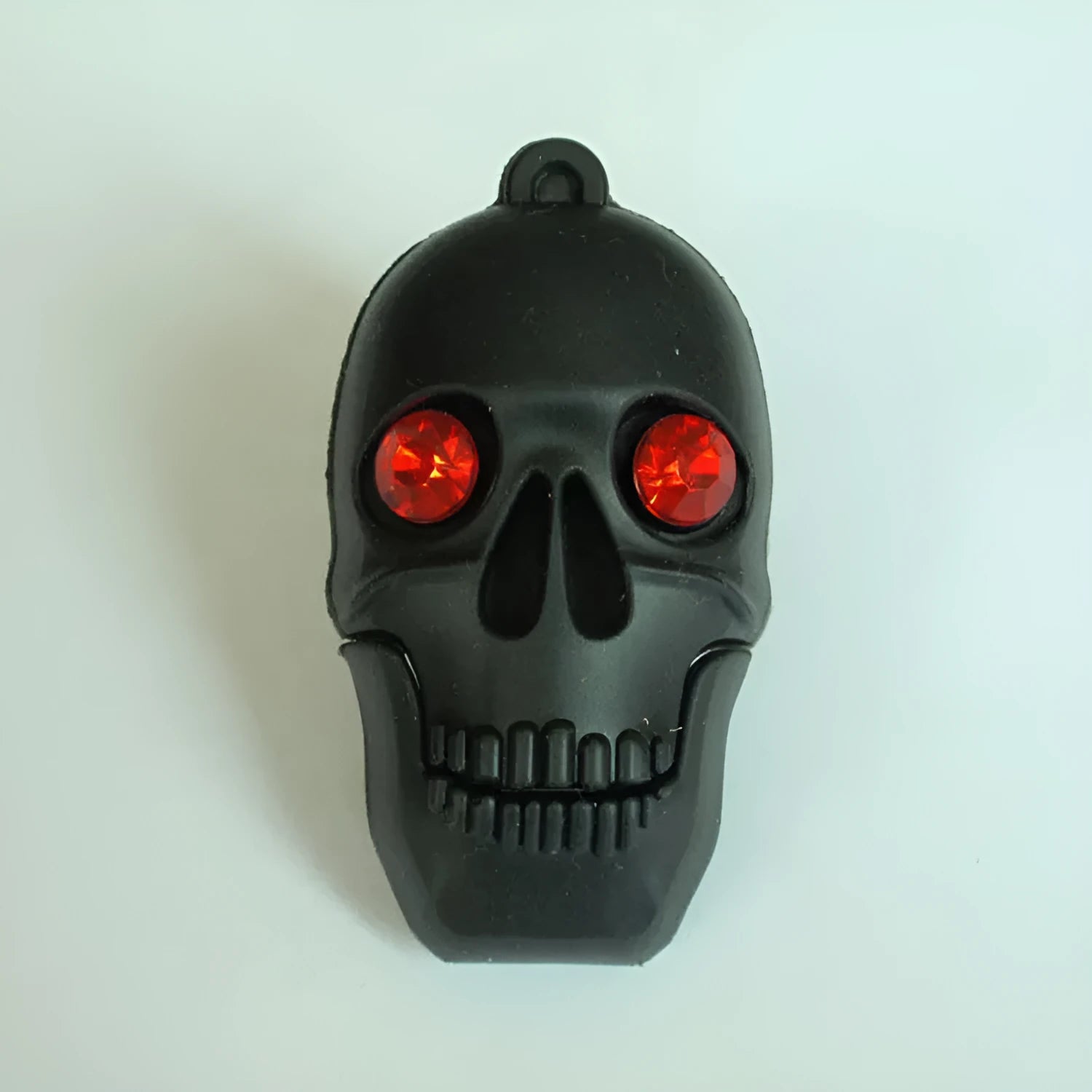 Skull skeleton shaped USB flash drive on a keychain, showing front and side views.