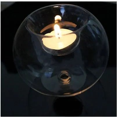Handmade European hollow glass candle holder in round geometric design on table.