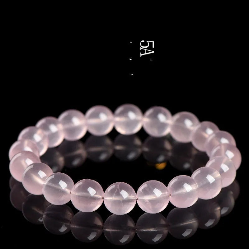 A polished natural starlight crystal bead bracelet in pink, shown as a single circle.