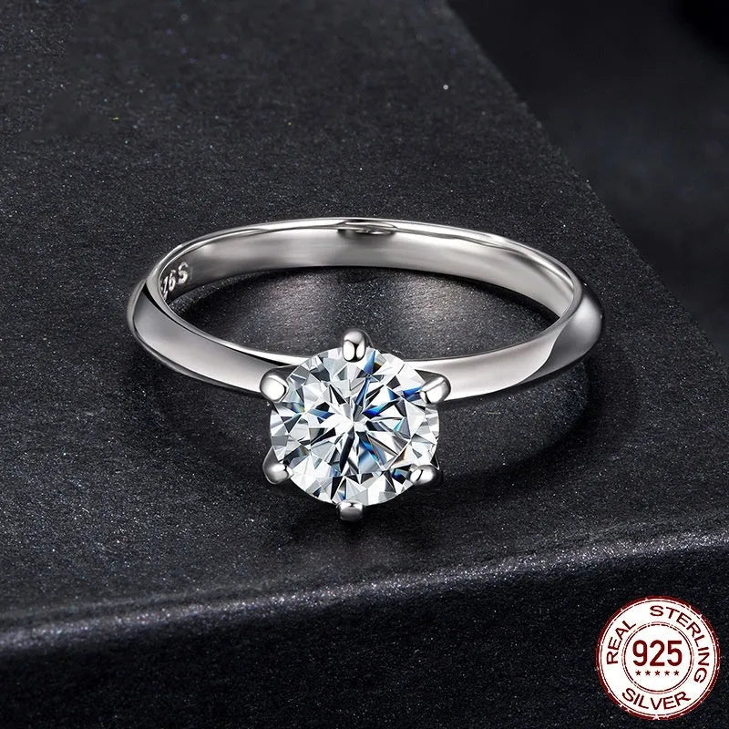 Simple classic 6 claw 1 karat moissanite ring in silver on white background, US size 7