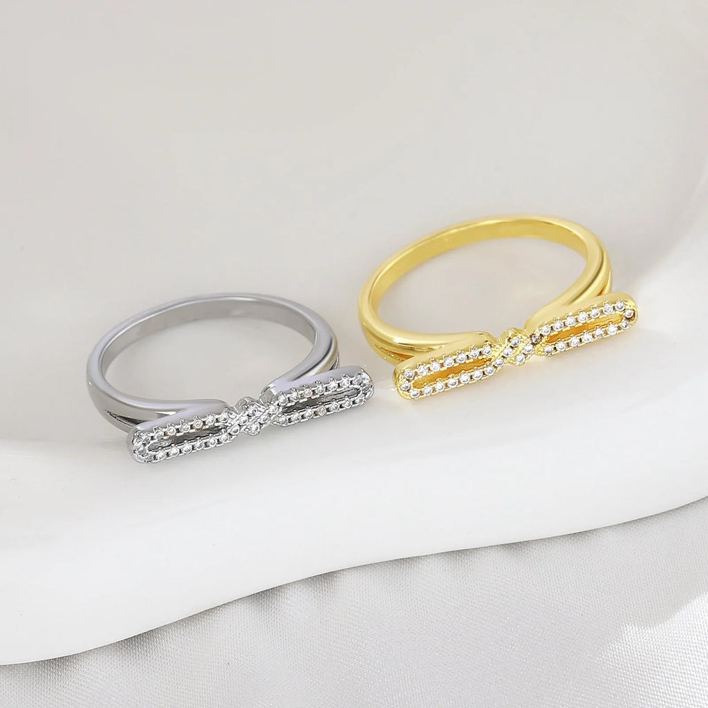 Fashion bowknot ring for women, copper with electroplated gold finish, bow shape on white background