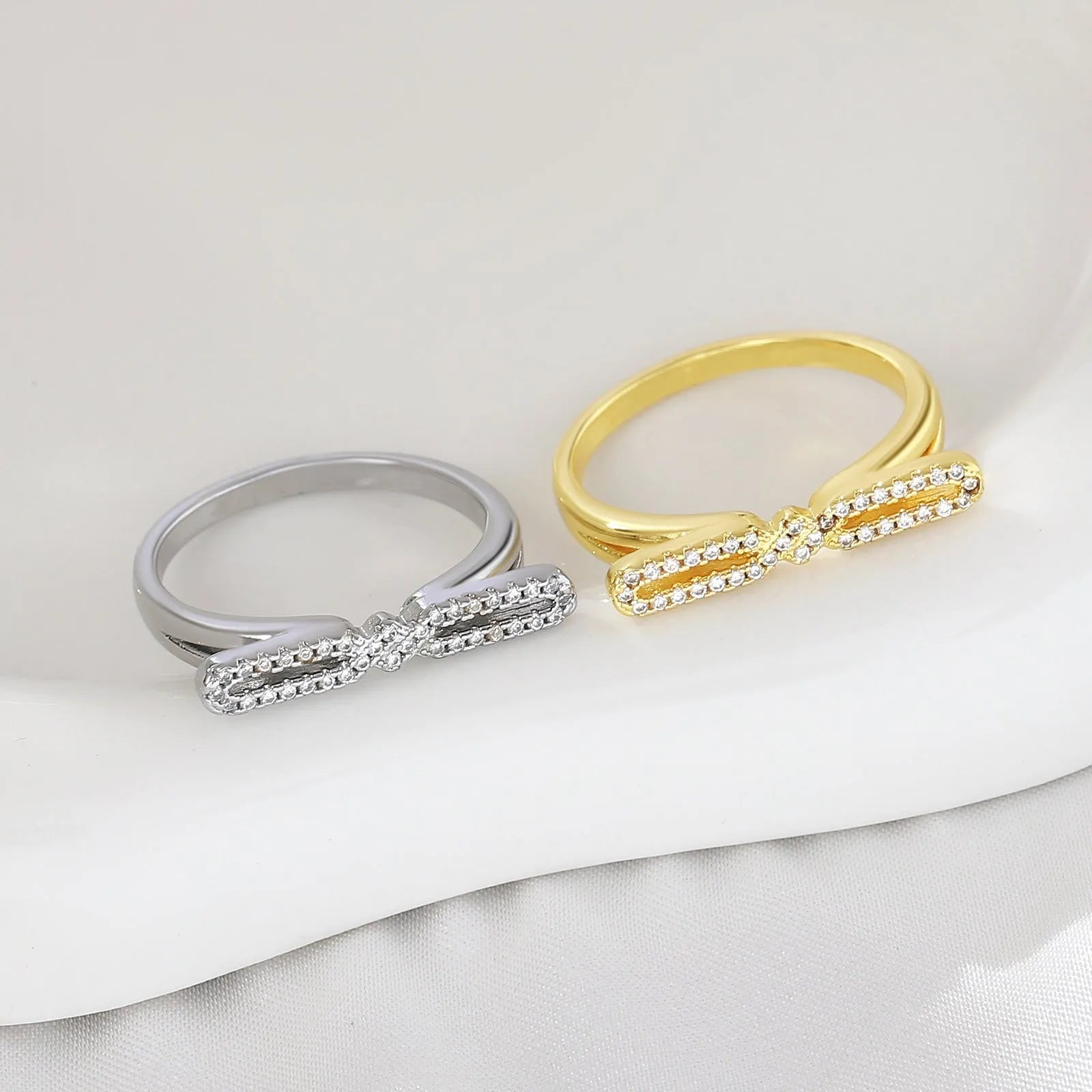 Fashion bowknot ring for women, copper with electroplated gold finish, bow shape on white background