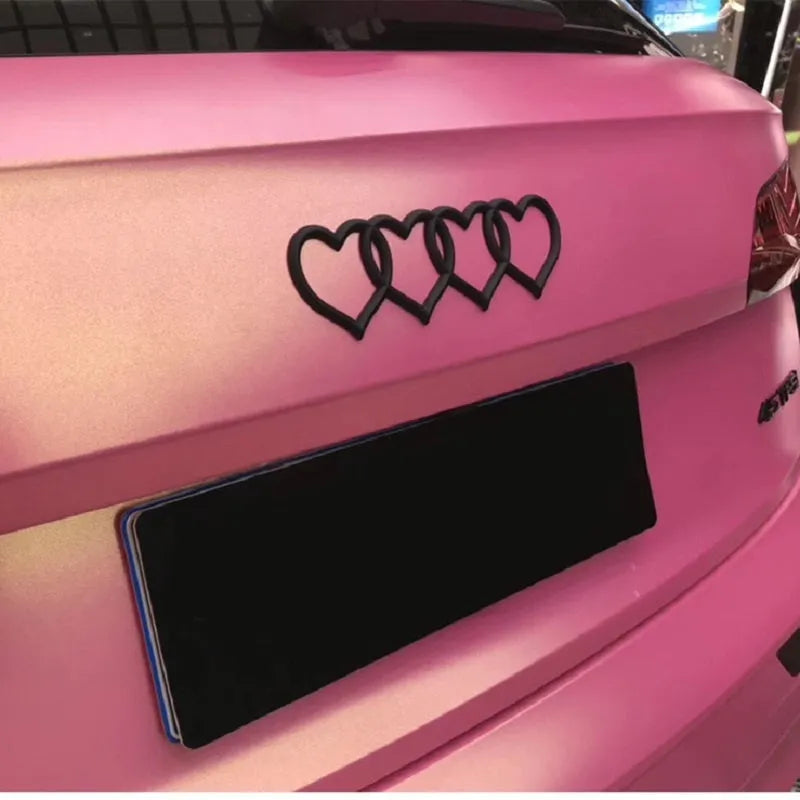 Heart-shaped body sticker with four-ring tail design in electroplated silver colour on a car bumper