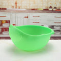 Plastic rice washing sieve in blue on a kitchen countertop with rice grains visible inside