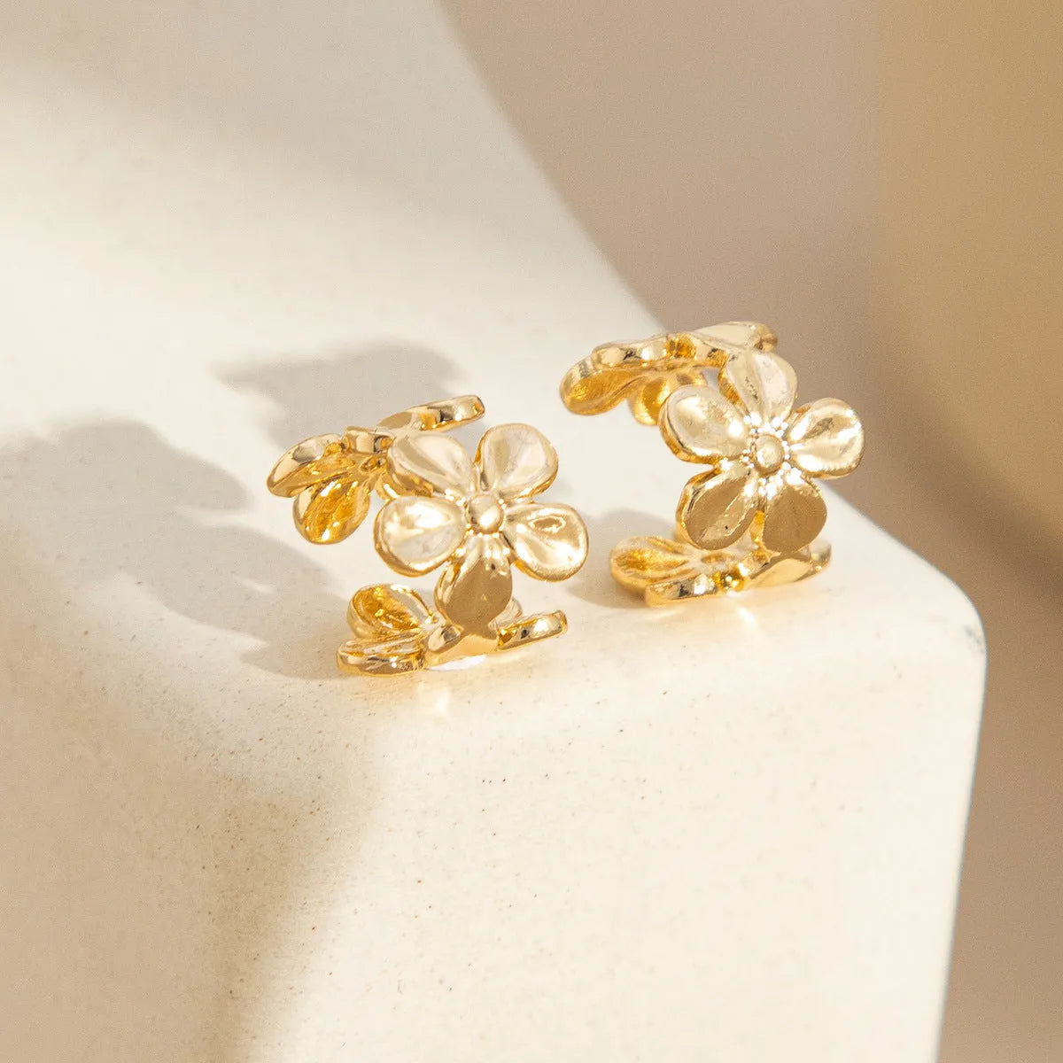 Gold starfish and conch shell earrings for women on a white background.