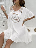 Crochet stitch patchwork beach cover-up dress in apricot colour, showing tassel details and textured fabric.