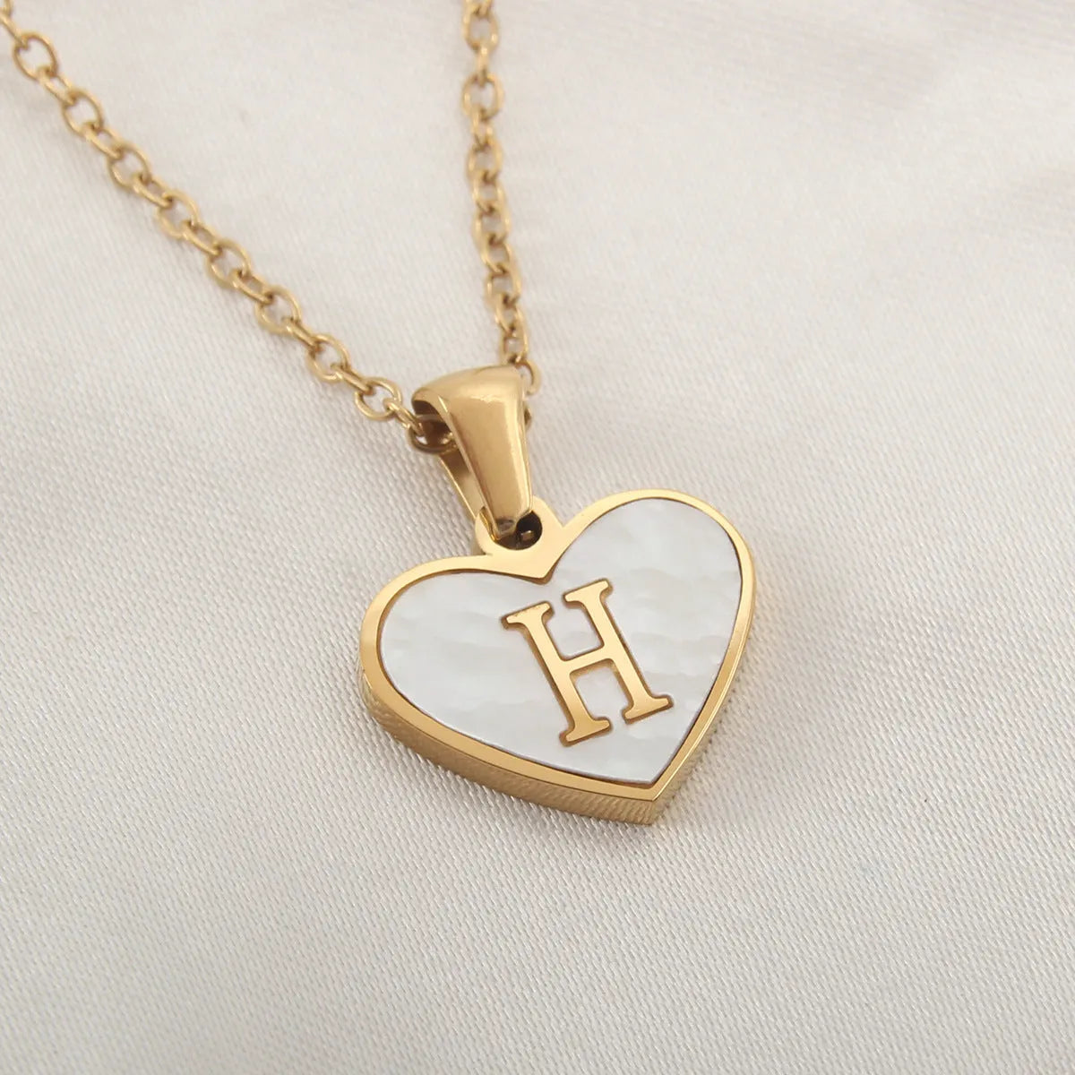 Gold heart necklace with white shell pendant and initial charm on 45cm adjustable chain
