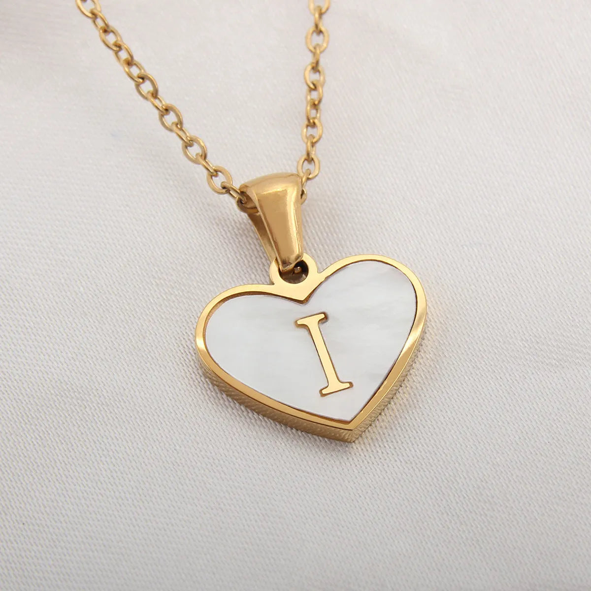 Gold heart necklace with white shell pendant and initial charm on 45cm adjustable chain