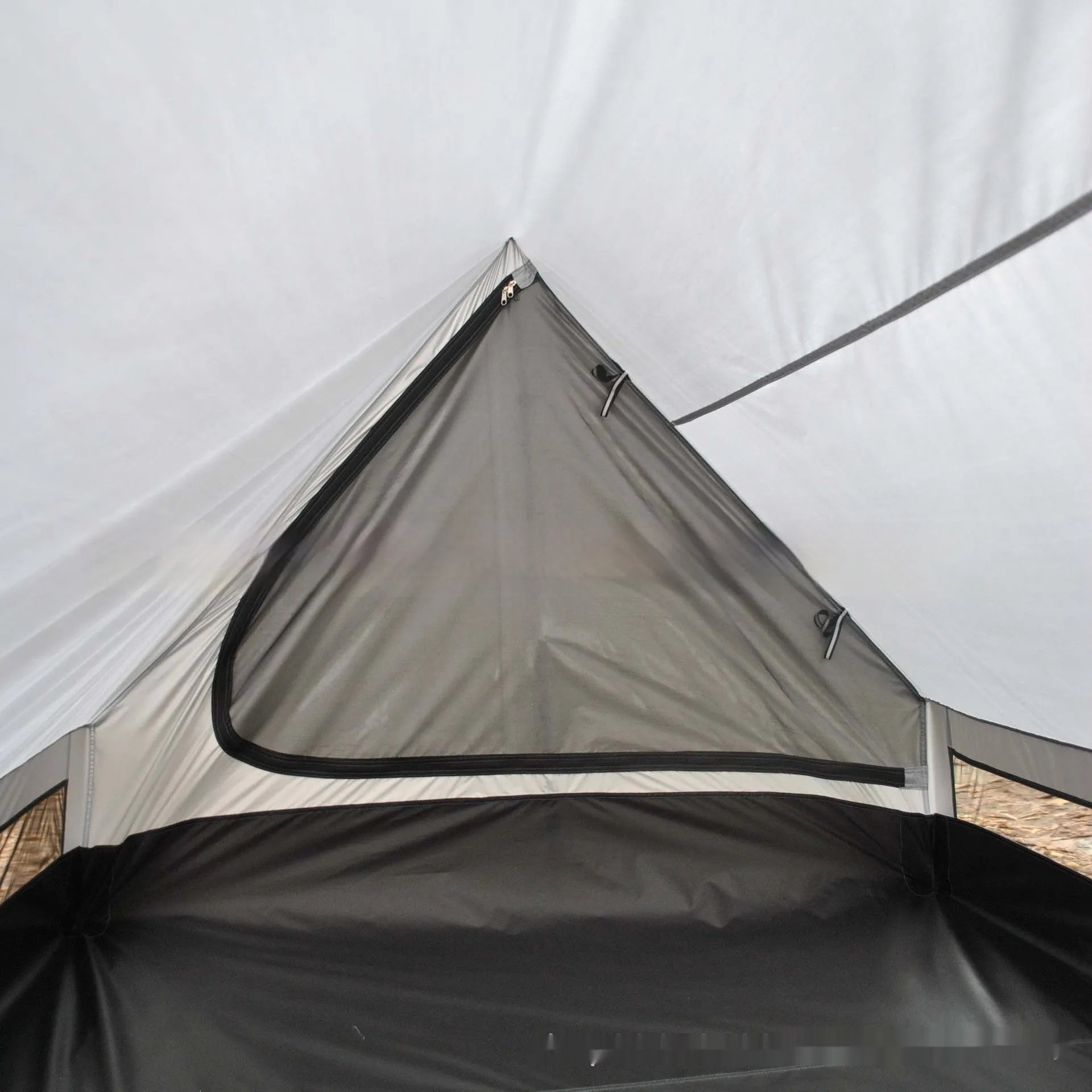 Brown or white A-frame pole-free cabin tent erected with hiking cane supports
