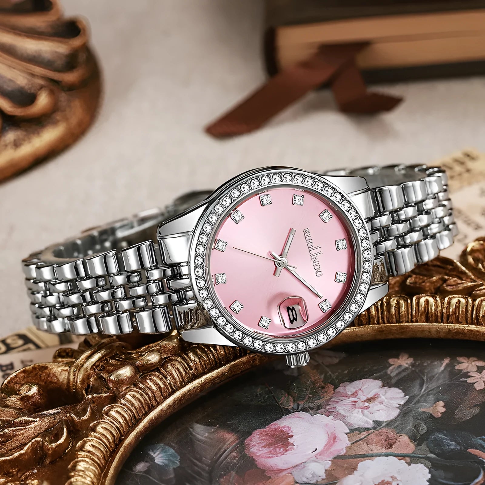 Women's silver alloy quartz calendar watch with circular dial and stainless steel folding buckle on wrist.