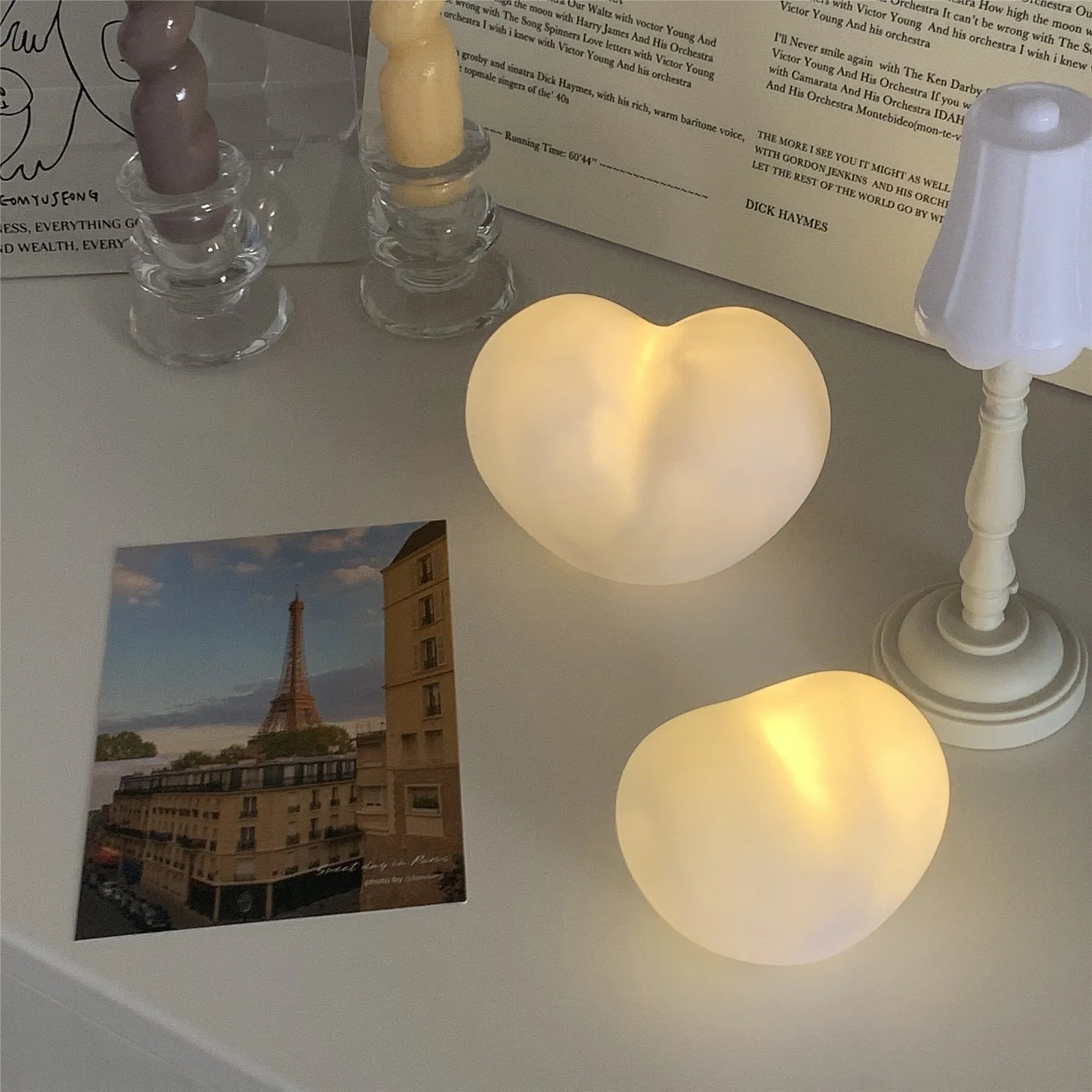 Pink and white vinyl atmosphere desk lamps in small and large sizes with warm LED glow.