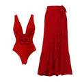 Red women's V-neck one-piece swimsuit with open back and detachable flower, shown with matching skirt.