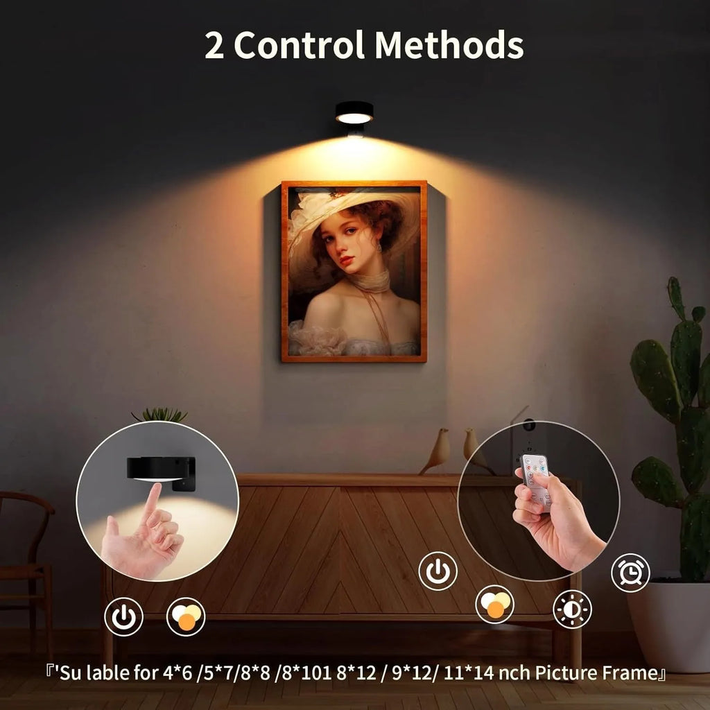 Wireless magnetic LED picture light with remote control in black, mounted on a painting frame.