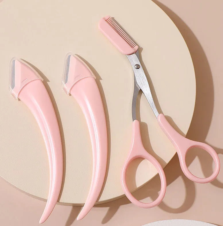 White and pink curved moon-shaped eyebrow trimming knife with a comb on a white background.