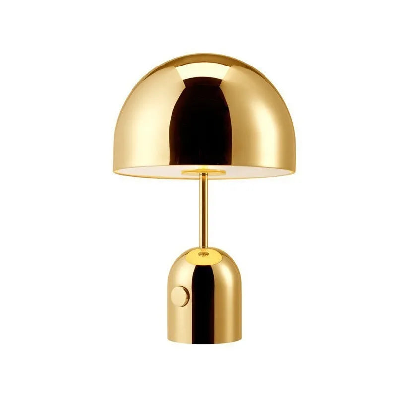 Mushroom-shaped metal table lamp in rose gold finish on a wooden table.