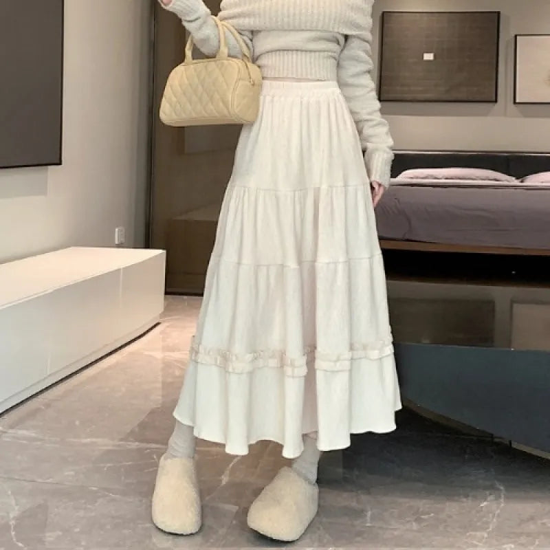 Korean urban style corduroy A-line midi skirt with elastic waistband in milky white colour on a hanger.