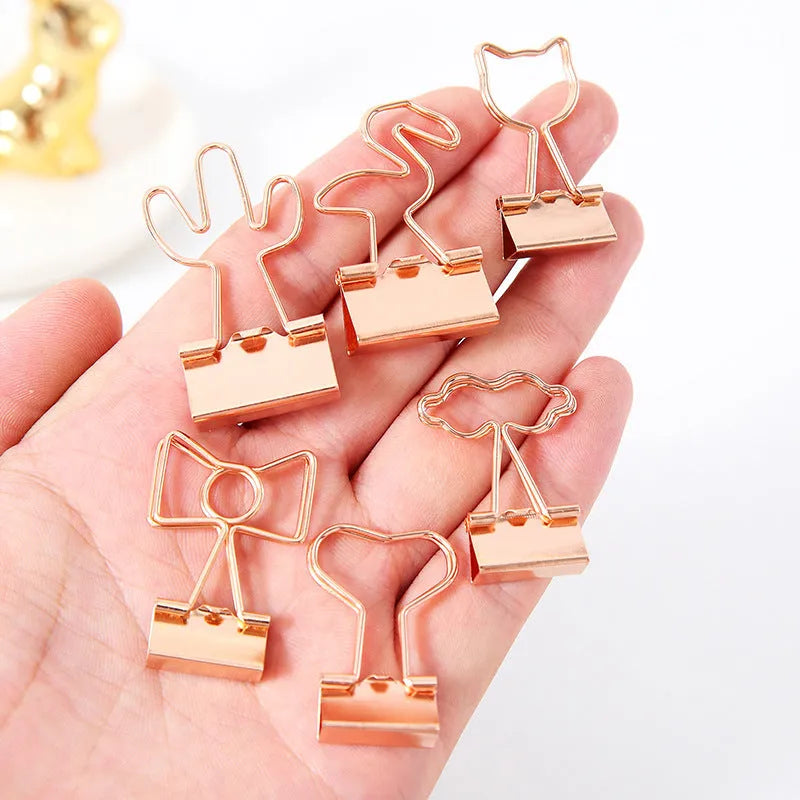 Gold-plated long tail hair clip showing decorative motifs including flamingo, love, clouds, cat, cactus, and bow designs