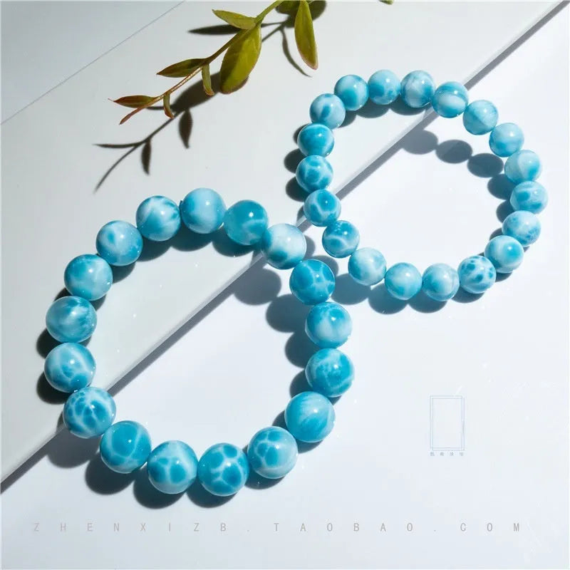 Blue Bodhi bead bracelet with a natural crystal sea-pattern stone charm on a wrist.