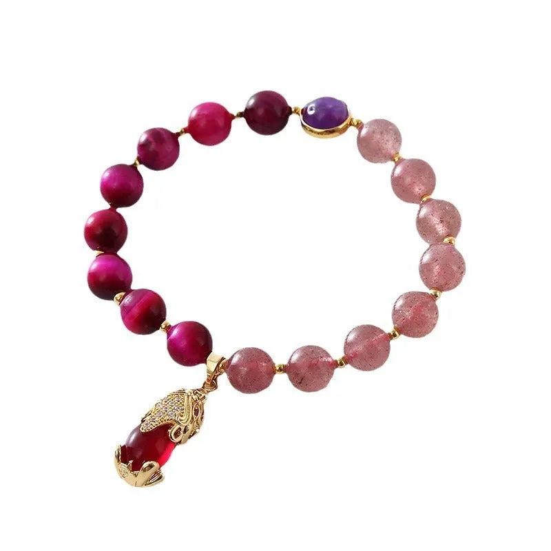 Simple bracelet with a red strawberry crystal on a black elastic rope.