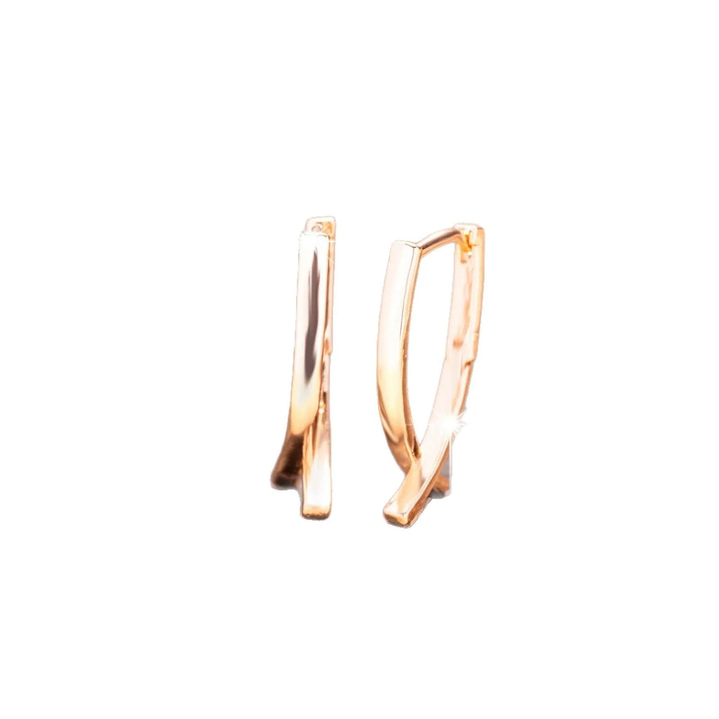 Rose gold coloured cross shaped earrings on a copper base.