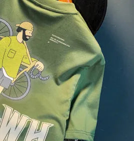 Green loose fit men's t-shirt with a front graphic print and short sleeves on a hanger.