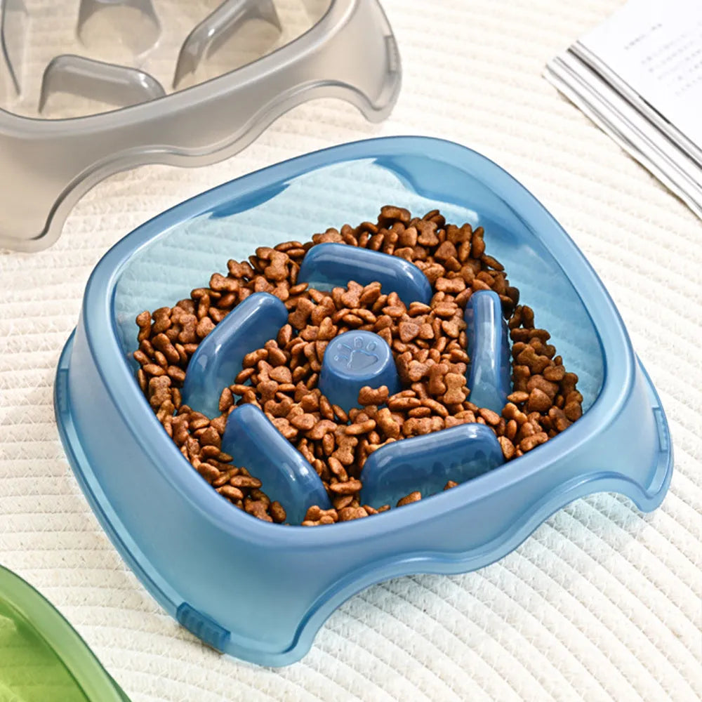 Blue plastic slow feeder dog bowl with anti-choking design on a white surface.