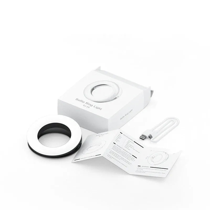 Black USB-rechargeable LED selfie ring light for mobile phone photography on a table.
