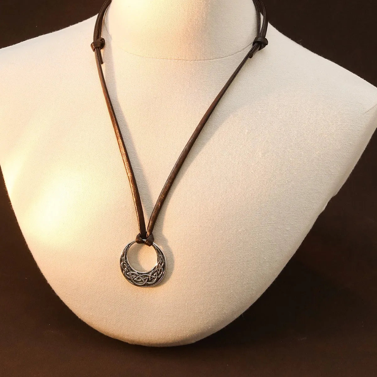 Alloy skull pendant necklace with adjustable knot chain in antique silver on a neutral background