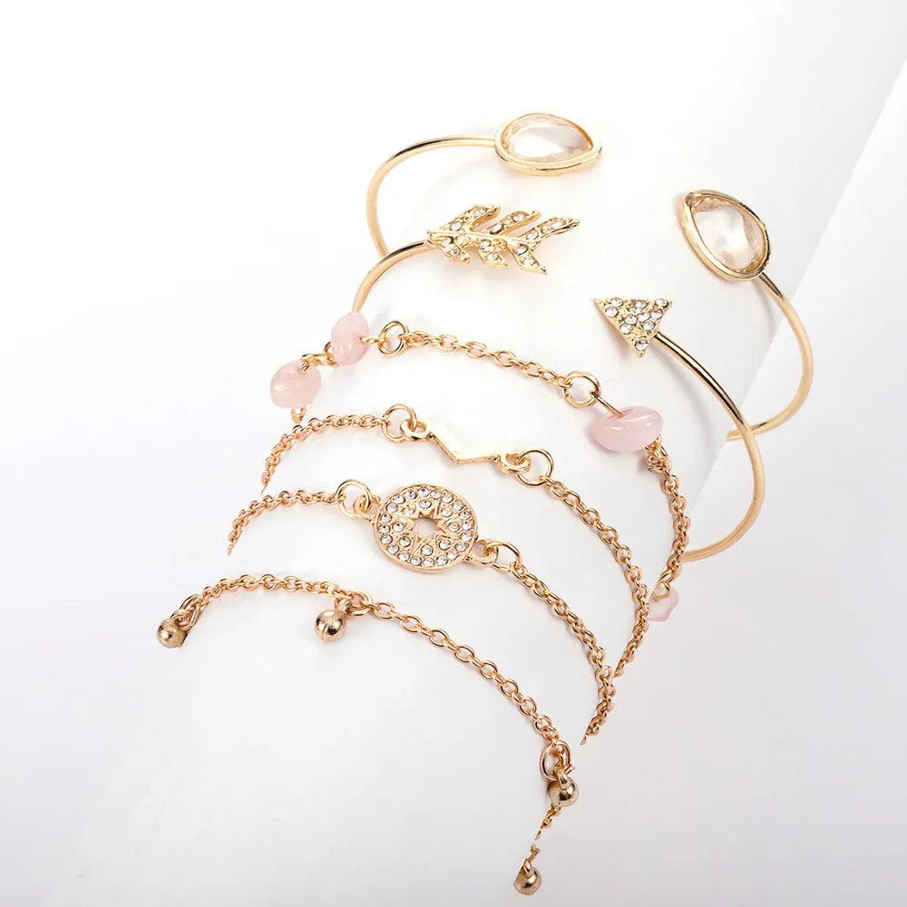 Gold-coloured women's bracelet set with six charms: arrow, water drop, and V shapes.
