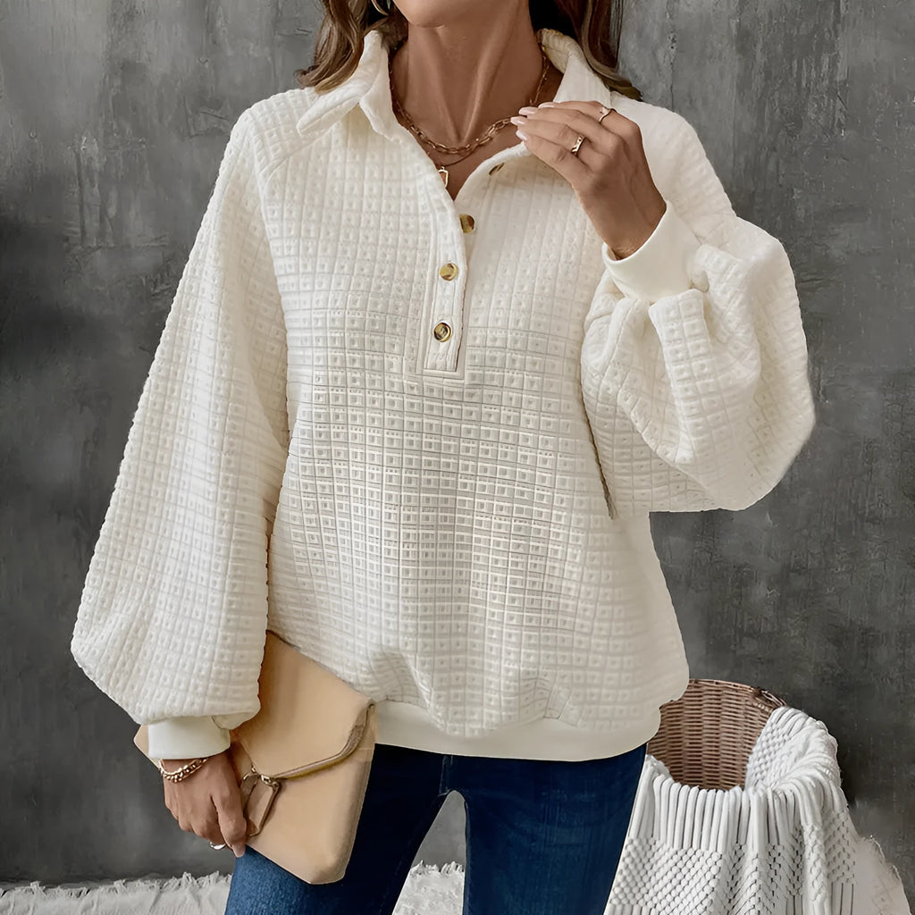 Women's milky white textured polo collar chunky knit sweater laid flat.