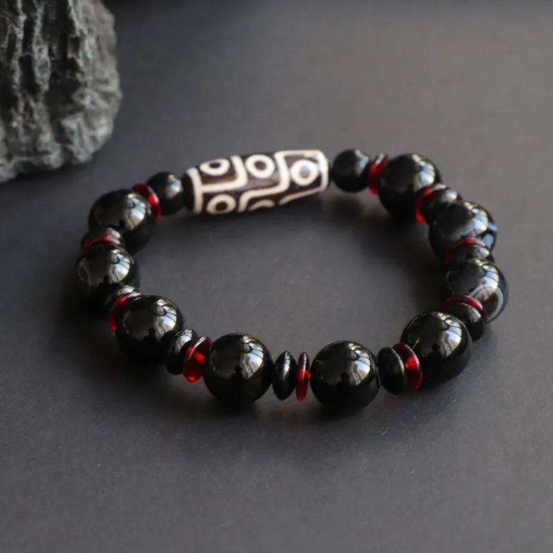 Black agate Dzi bead bracelet with hand-woven construction and geometry beads.