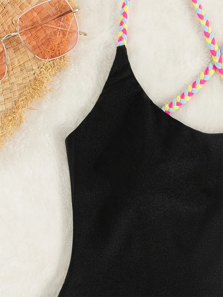 Black backless sleeveless one-piece swimsuit laid flat.