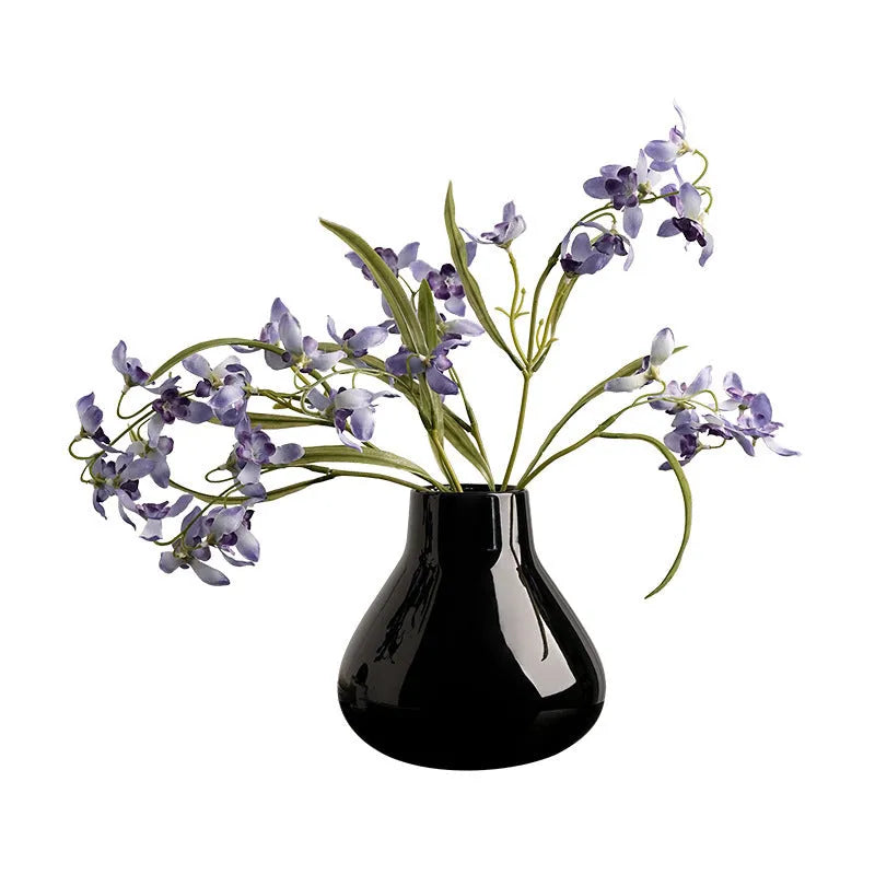 Ceramic round belly vase with coloured glaze finish in black or white, shown with artificial orchid stems