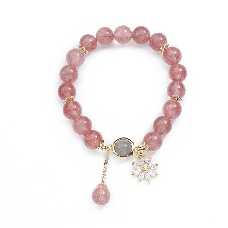Mori style crystal bracelet with strawberry quartz stones and floral design details on a wrist.