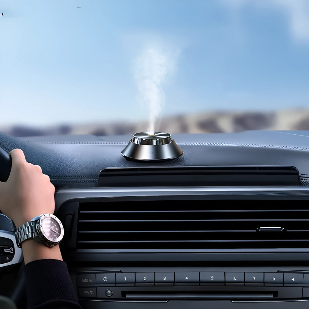 Black metal car air purifier with butterfly design, USB cable, and essential oil bottle.