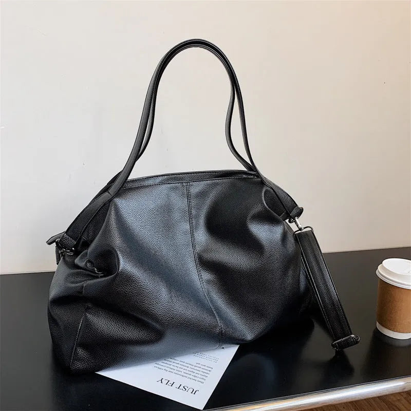 Large soft surface messenger bag showing horizontal square shape with adjustable shoulder strap and zip opening