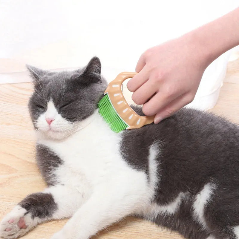 Green shell-shaped plastic pet grooming comb with bent wire bristles and an anti-slip handle.