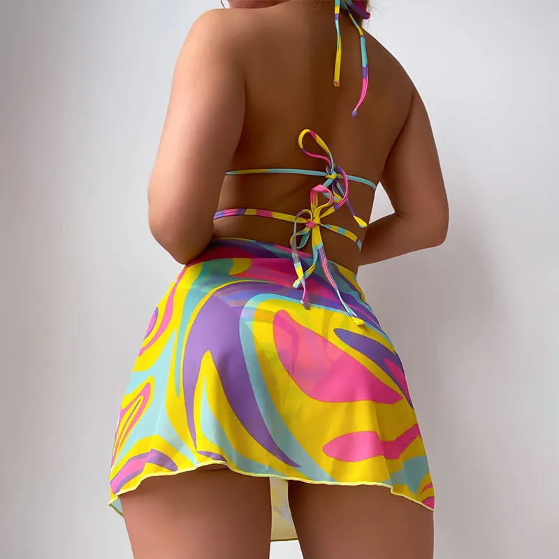 Yellow striped halter neck swimsuit with front lace-up detail, worn with matching skirt and shorts.