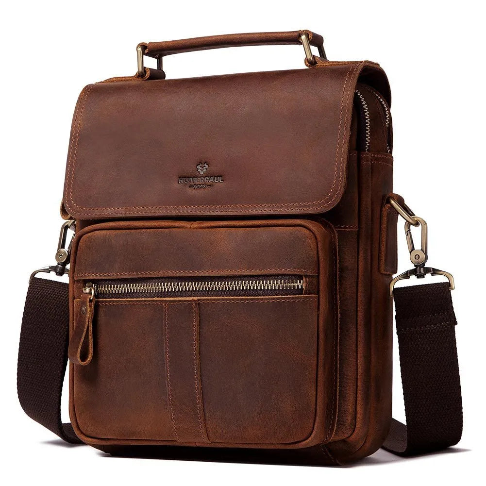 Men's brown leather shoulder bag with zipper buckle closure on soft surface