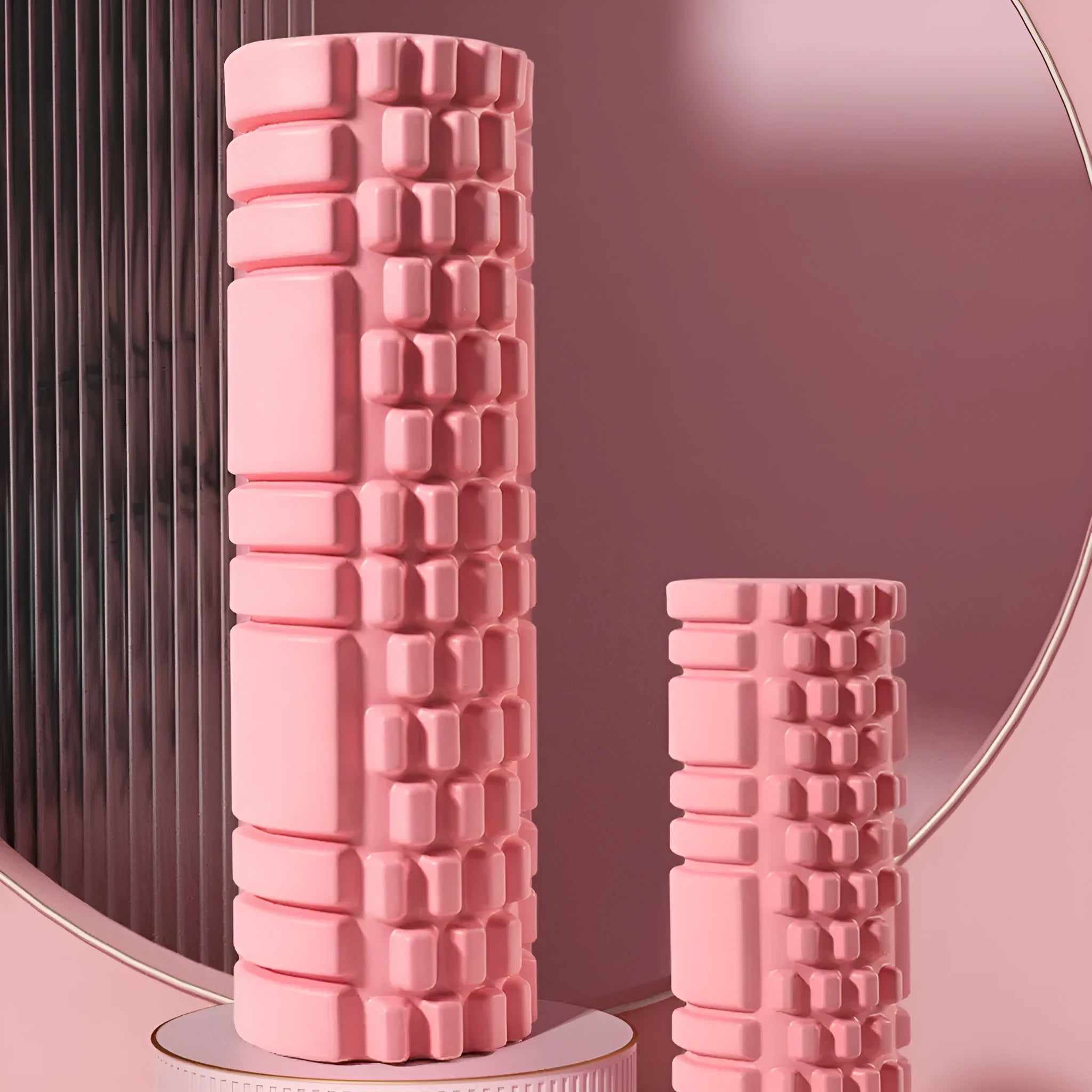 A black EVA foam roller for fitness and muscle recovery, shown next to a grey and pink version.