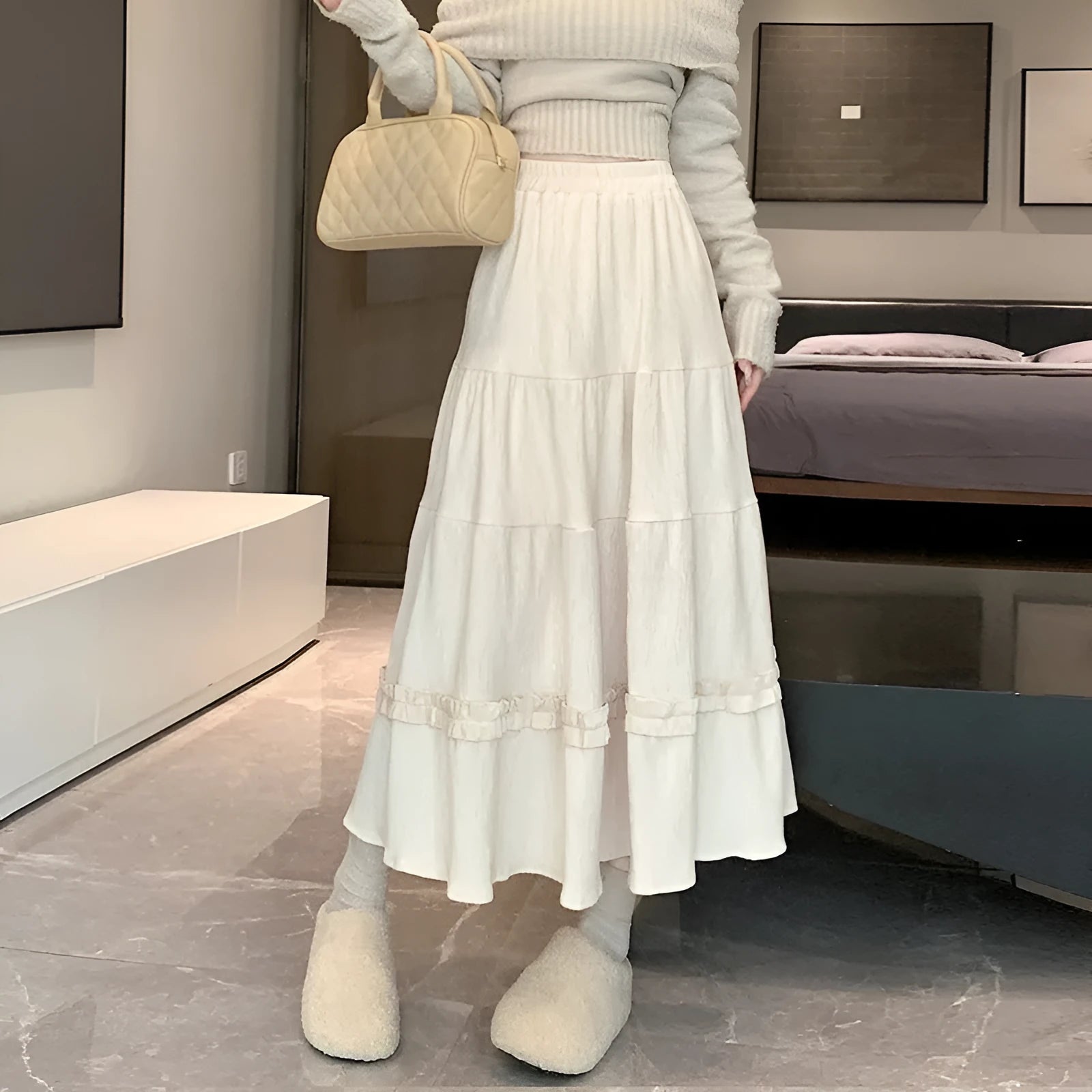Korean urban style corduroy A-line midi skirt with elastic waistband in milky white colour on a hanger.