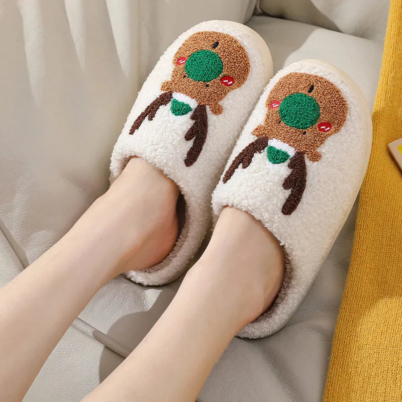 Pair of red Christmas elk plush home slippers on floor, soft anti-slip shoe design