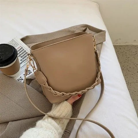 Unisex khaki PU leather crossbody bucket bag with woven texture and one shoulder strap.
