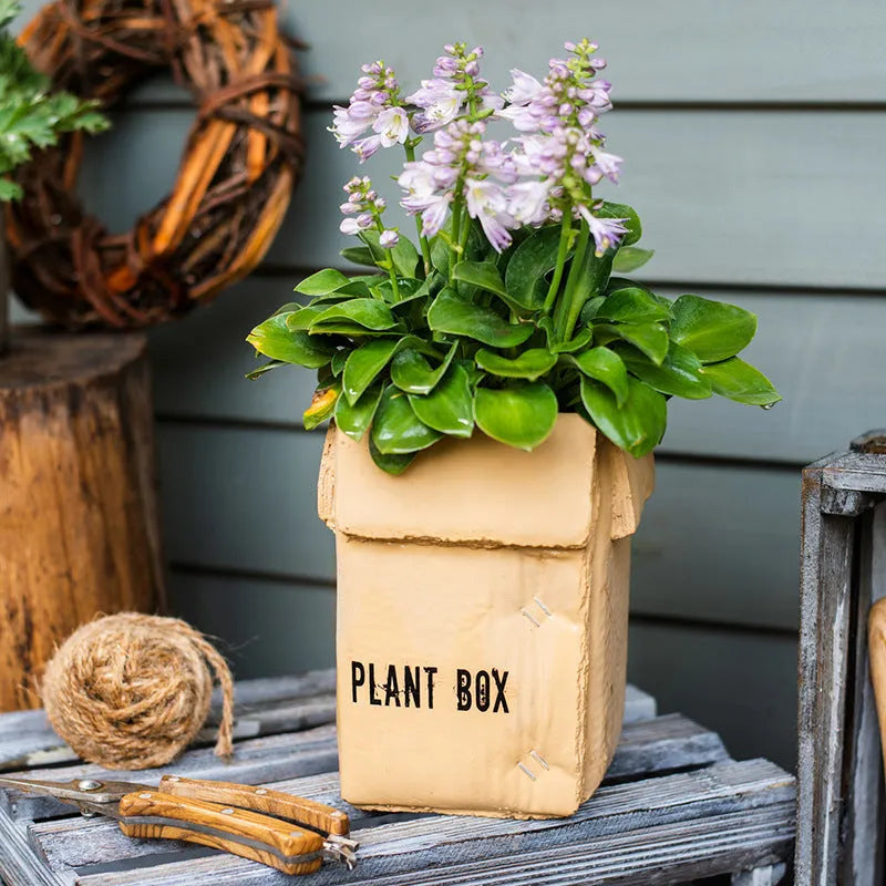 Cement flowerpot with bottom drainage holes and paper box texture in Nordic style design
