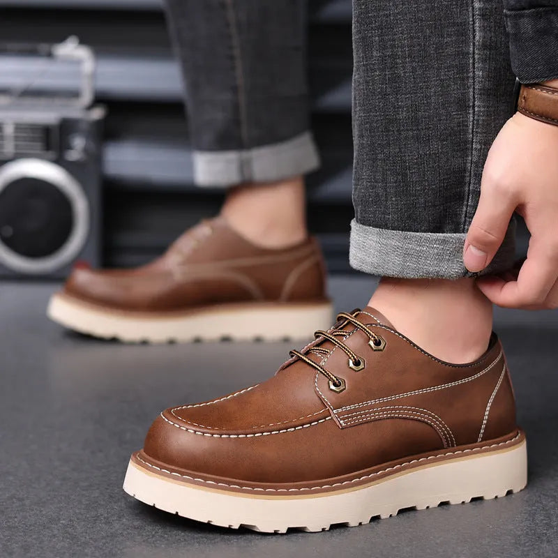 Men's black low-top Martin boots with a rounded toe and a textured rubber sole.