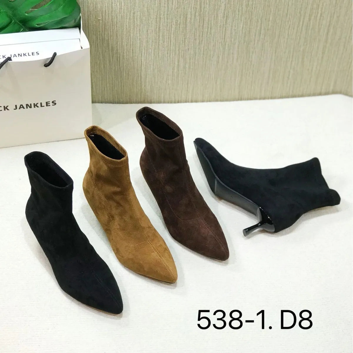 Black pointed toe stiletto heel ankle boots with a calf-high shaft on a neutral background.